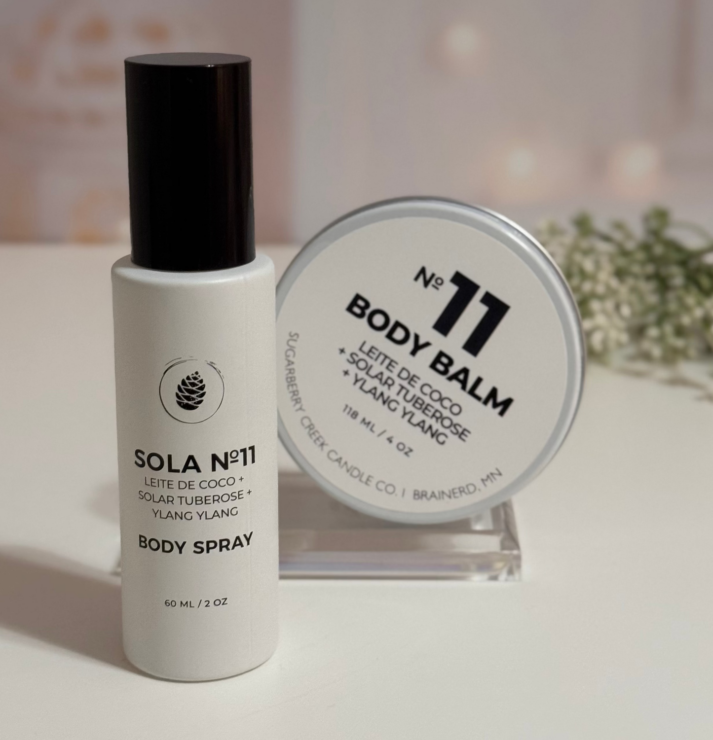 Body spray and balm on a white surface with a blurred background