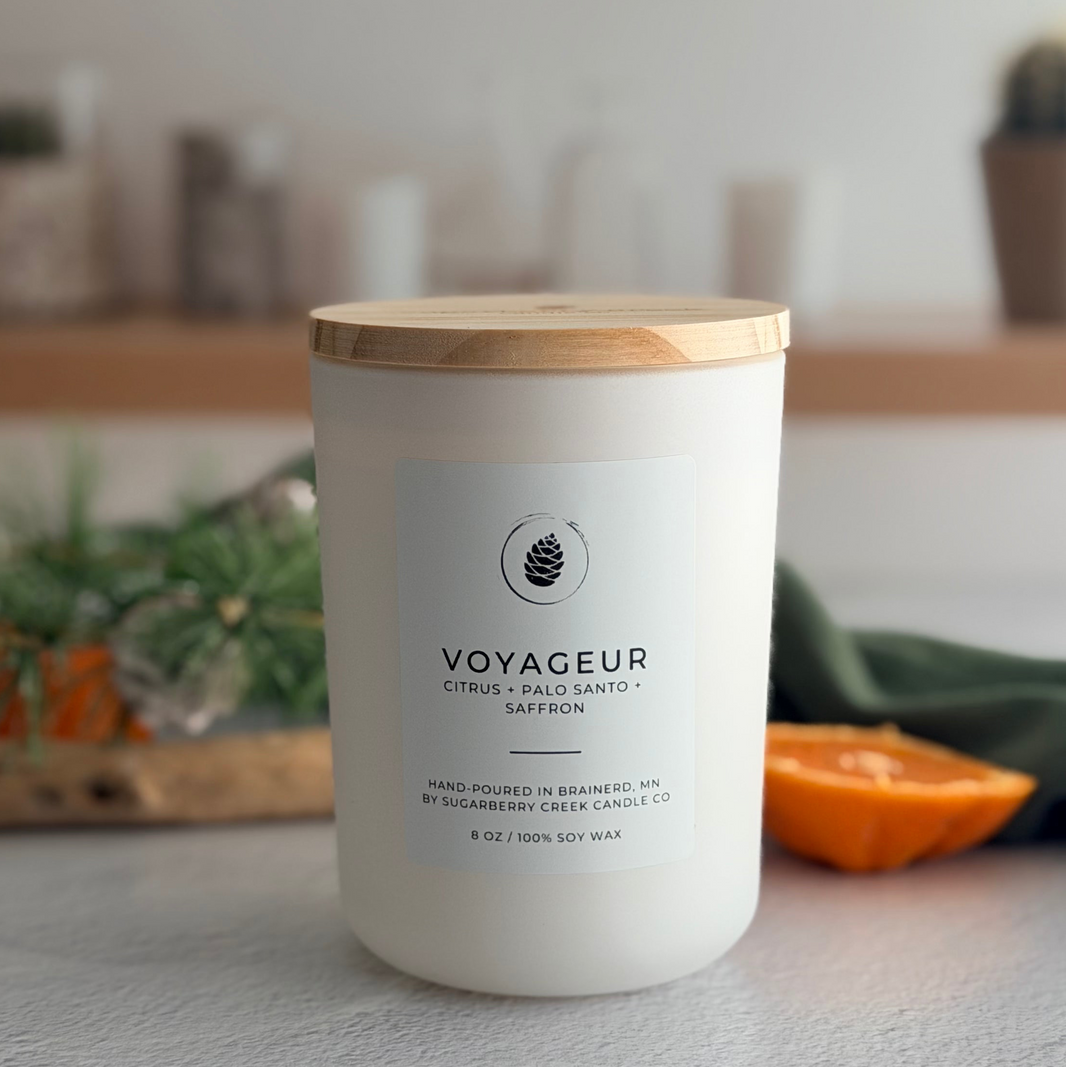 Voyageur candle with a wooden lid on a surface with a blurred background