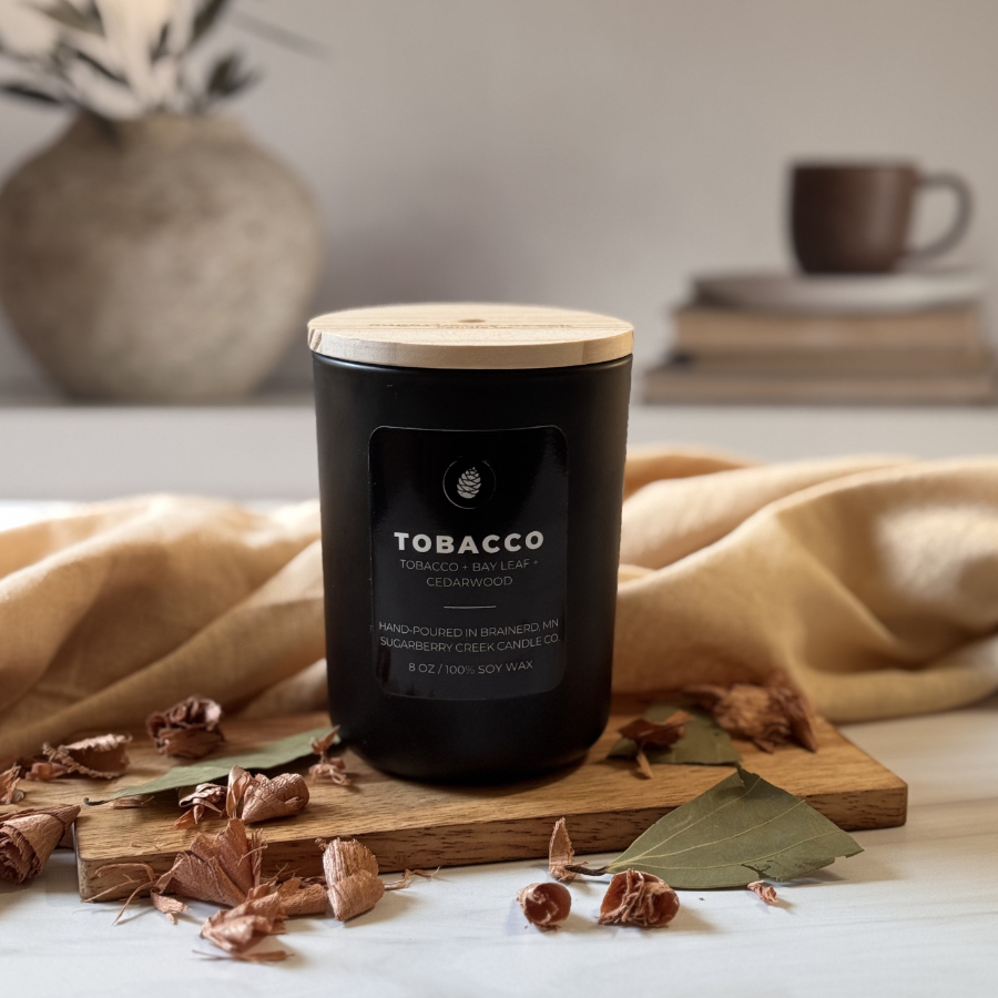 Tobacco candle on a wood tray with cedar and basil