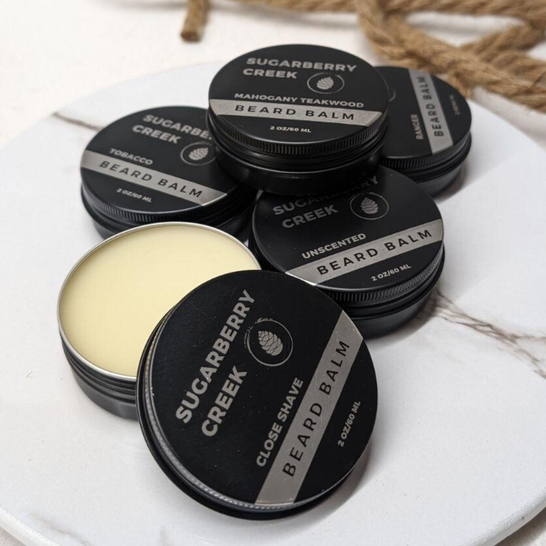Collection of Sugarberry Creek beard balm containers on a white, marble tray.
