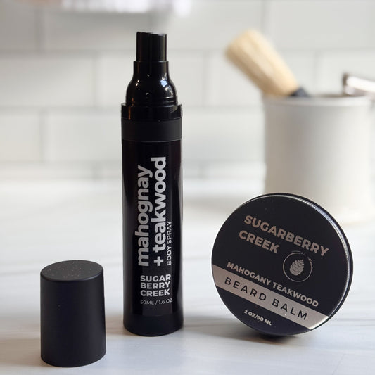 Mahogany + Teakwood body spray and bear balm with in front of a tile background