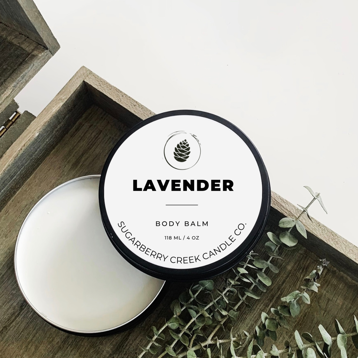 OPen Lavender body balm tin in a brown box with eucalyptus stems