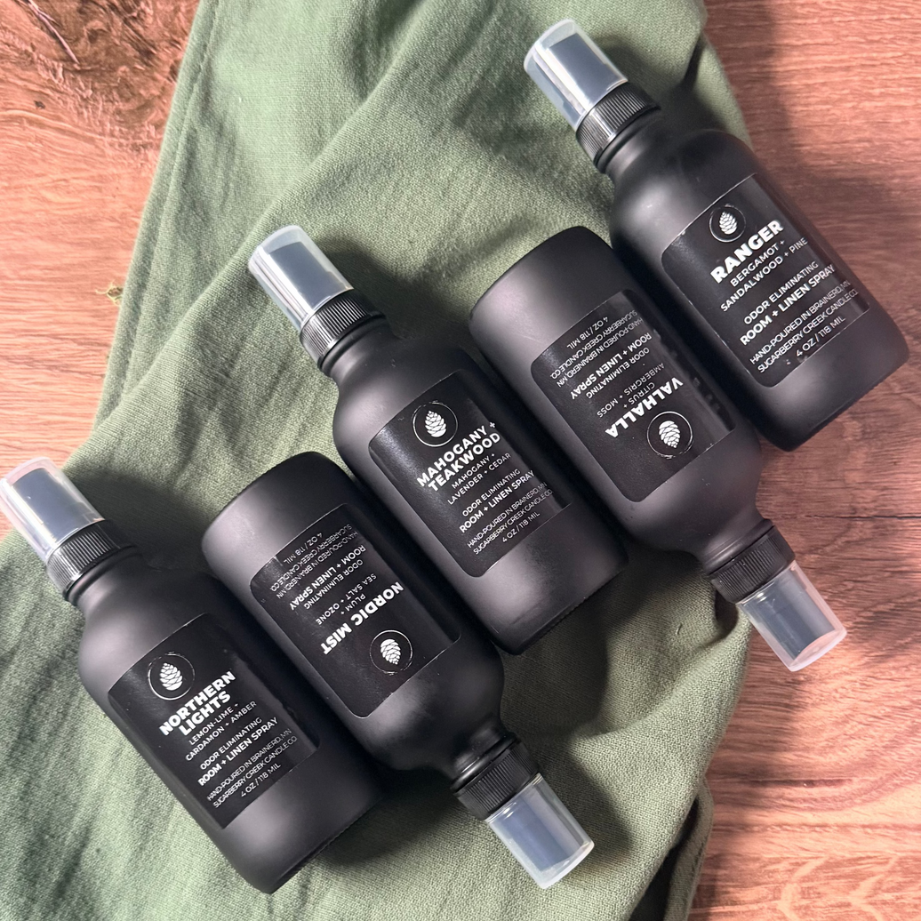 Black hair care products on a green towel with a wooden surface background