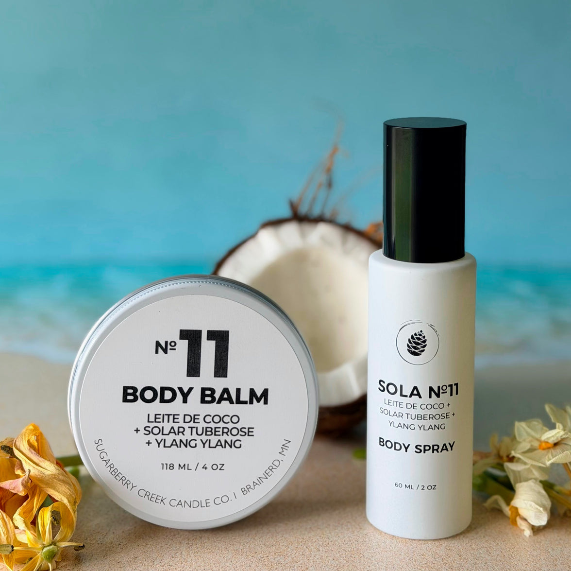 Body balm and spray with coconut and floral elements on a beach-themed background