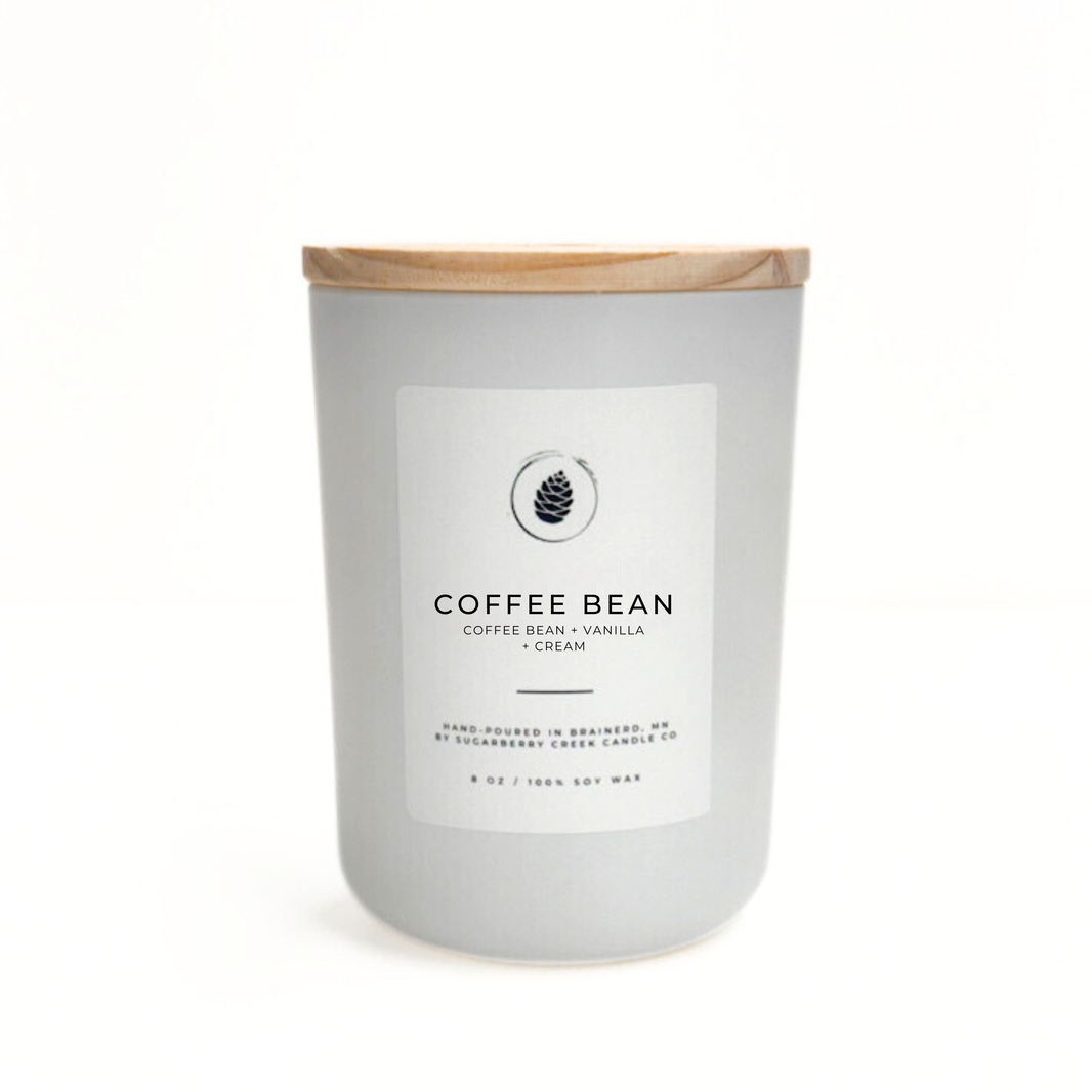 Candle with a label indicating 'Coffee Bean' fragrance on a white background