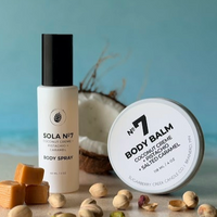 Body spray and body balm with ingredients on a light surface against a blue background